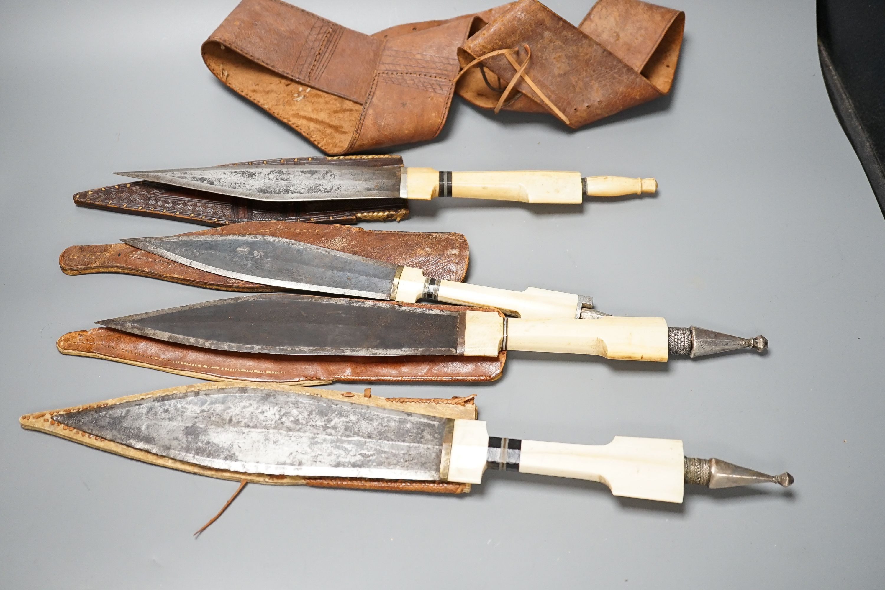 Four similar African tribal daggers c.1900, each with hippo tusk handle including two with silver pommels, all in their decorated leather scabbards with 1 belt, maximum 45cms.